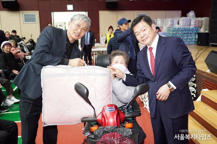 장애인재활증진대회에 참여한 이필형 동대문구청장(사진 오른쪽)이 행운권에 당첨된 주민에게 경품을 전달하고 있다.