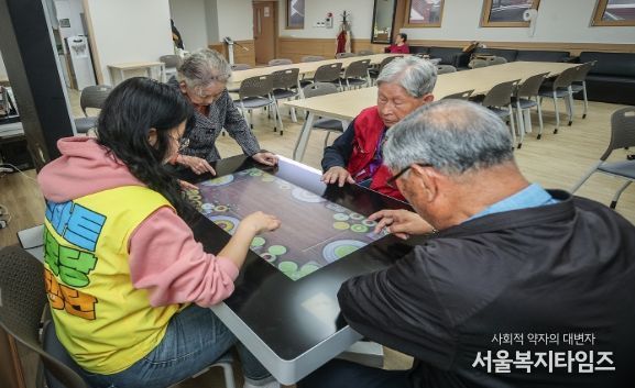 양천구 신원 스마트경로당에서 동행매니저와 스마트테이블을 이용 중인 어르신들의 모습