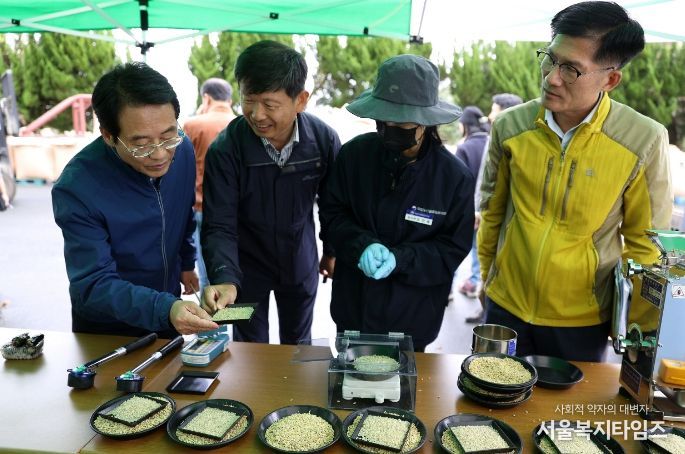 강진원 군수가 도정된 햅쌀을 보며 관계자들과 공공비축미에 대한 이야기를 나누고 있다.