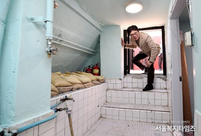 반지하에 살던 주민이 이주한 공간을 살펴보는 정원오 성동구청장. 해당 반지하 주택의 출입문은 허리를 굽혀야 겨우 출입이 가능하다.