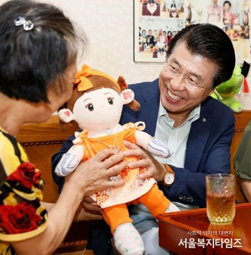‘24. 9월 추석 전 한 어르신댁을 위문방문한 서 구청장이 AI 반려로봇 ’효손이‘를 바라보고 있다.