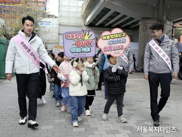 오언석 도봉구청장이 지역 아이들과 함께 창동역 1번 출구를 걸으며 아동학대 예방 캠페인을 하고 있다