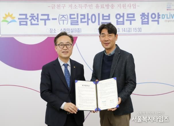 유성훈 금천구청장(사진 왼쪽)이 김덕일 ㈜딜라이브 대표이사(사진 오른쪽)와 협약서에 서명 후 기념촬영을 하고 있다