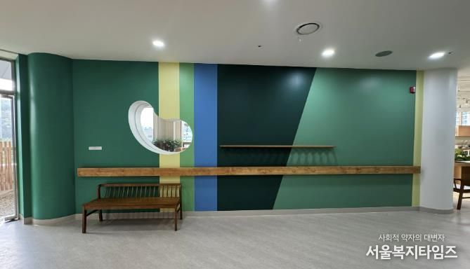 어르신 인지건강 증진을 위한 실내 다감각 정원 '소하담숲' 모습. 사진 오른편 내부 정원에서 왼편 외부 정원으로 나가는 복도의 벽을 자연의 색을 재해석한 색으로 칠했다.