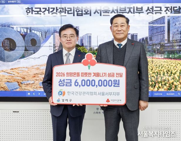 진교훈 서울 강서구청장(왼쪽)이 구청장실에서 열린 ‘한국건강관리협회 서울서부지부 이웃돕기 성금 전달식’에서 김민수 본부장으로부터 성금을 전달받고 기념촬영을 하고 있다.