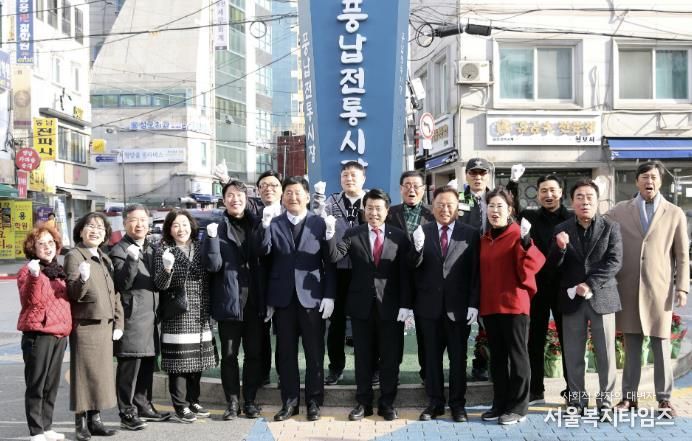 서강석 송파구청장(가운데)이 풍납시장 간판어닝 개선사업 준공현장에 방문해 주민들과 함께 기념촬영을 하고 있다