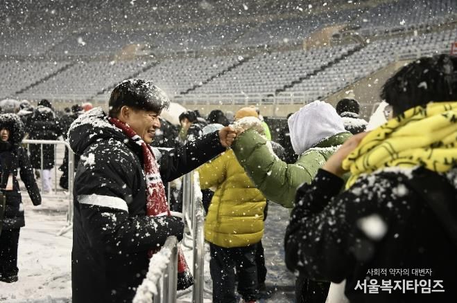 부천FC1995의 승강 PO 1차전이 폭설로 연기된 후 돌아가는 시민들과 조용익 부천시장이 주먹인사를 나누고 있다.