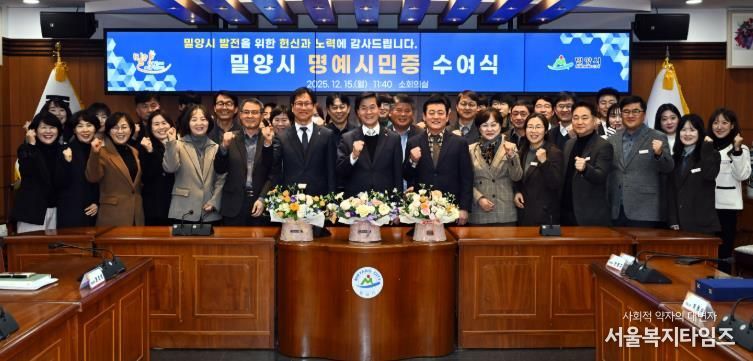 2: 15일 밀양시청 소회의실에서 열린 명예시민증 수여식 참석자들이 함께 기념 촬영을 하고 있다.