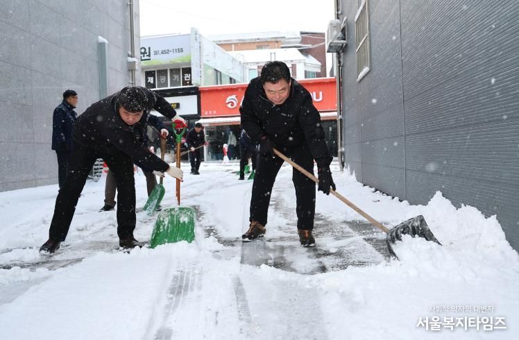 김산 군수와 공무원들이 무안읍 시가지에서 제설 작업을 하고 있다