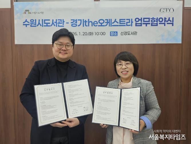 최현주 수원시도서관사업소장(오른쪽)과 허석환 경기더(the)오케스트라 관계자가 협약 후 기념촬영을 하고 있다.